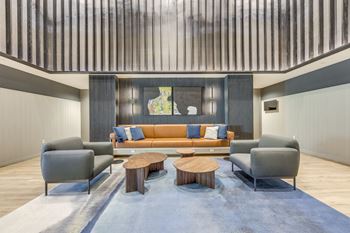 A living room with a couch, two chairs and a coffee table.